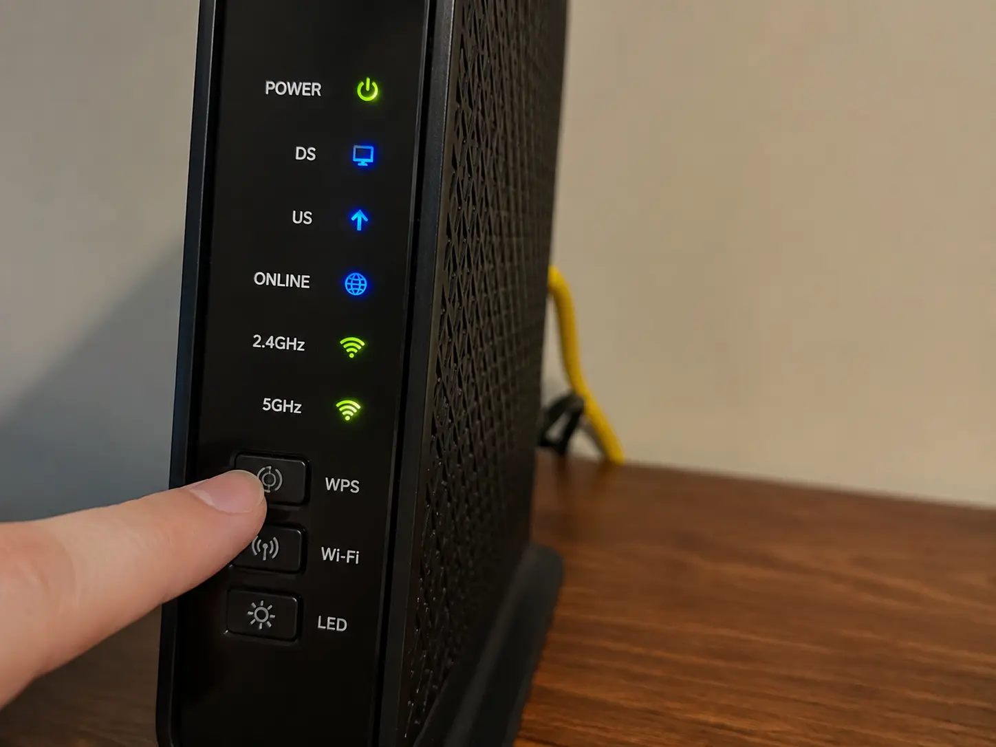 A close-up of a modern home router pointing out the circular physical WPS button on the back panel